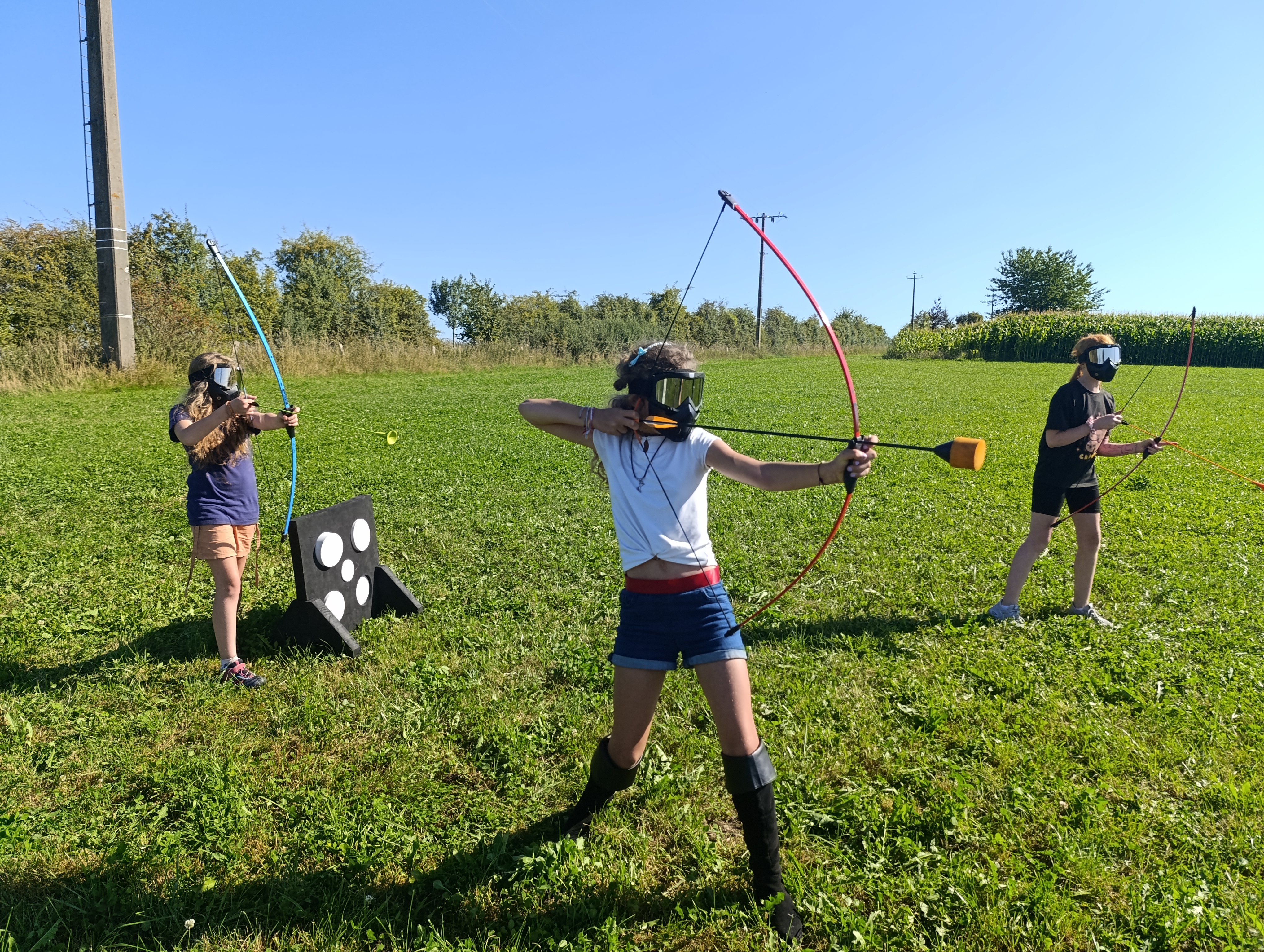 Photo de 3 enfants jouant à l'archery tag avec l'équipement du Famenne & Art Museum