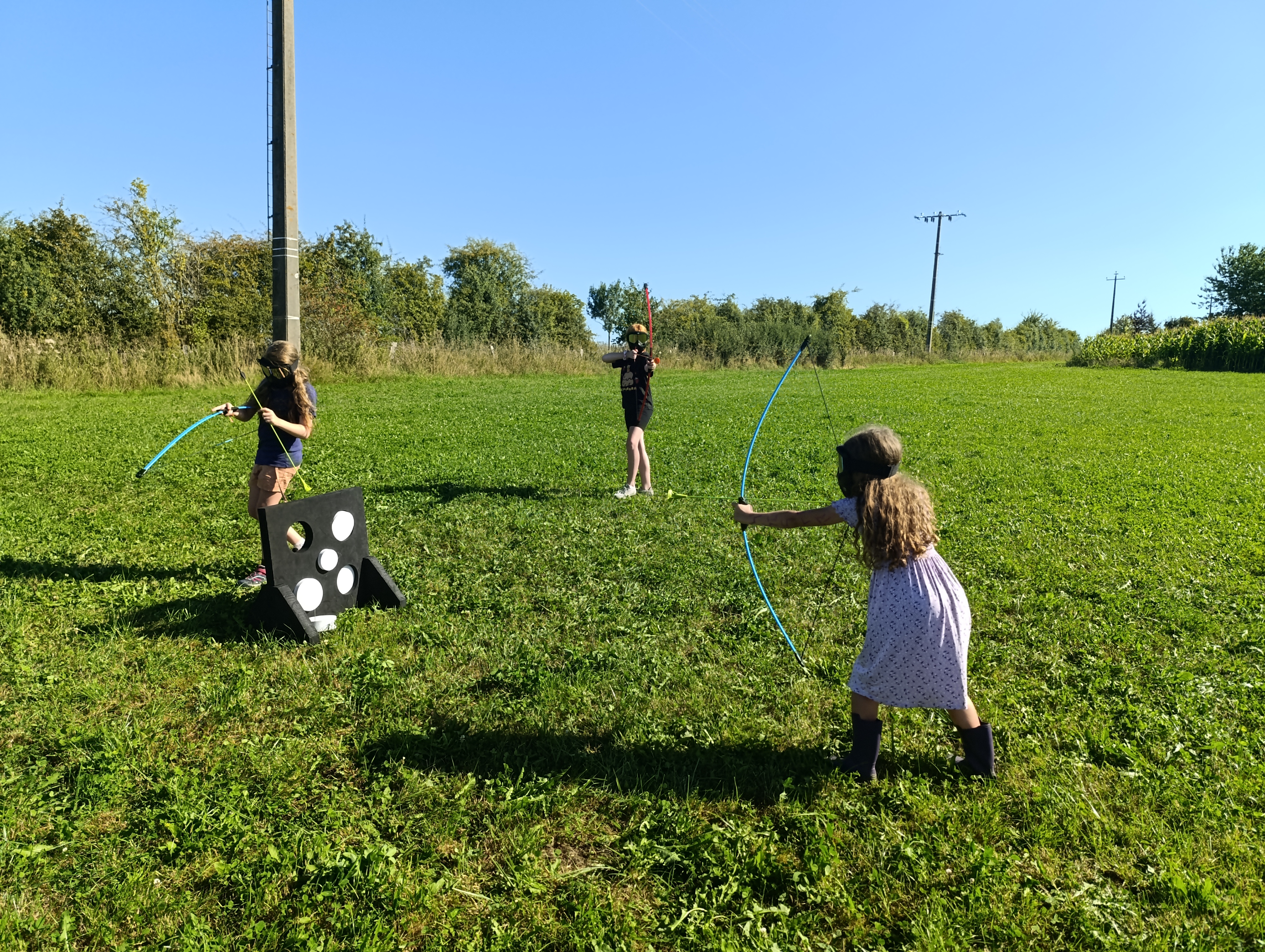 Photo de 3 enfants jouant à l'archery tag avec l'équipement du Famenne & Art Museum