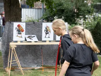 Photo de deux jeunes filles tirant avec des arcs pour enfants et flèches à ventouses sur des cibles basculantes