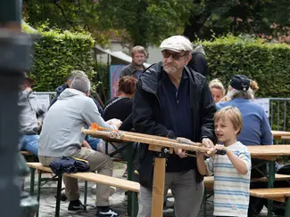 Photo d'un garçon visant un cible avec une reproduction ludique d'une baliste