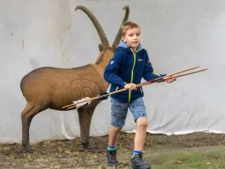 photo d'un garçon ayant tiré avec des reconstitutions de sagaies sur un faux bouquetin
