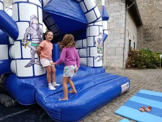 Photo d'enfant sur un trampoline en forme de château fort lors de la journée Archery FAM au Famenne & Art Museum