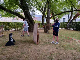 Photo de deux adolescents participant à un match d'archery tag dans le parc Jadot au Famenne & Art Museum