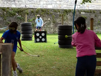 Photo de trois adolescents participant à un match d'archery tag dans le parc Jadot au Famenne & Art Museum