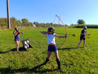 Photo de 3 enfants jouant à l'archery tag avec l'équipement du Famenne & Art Museum