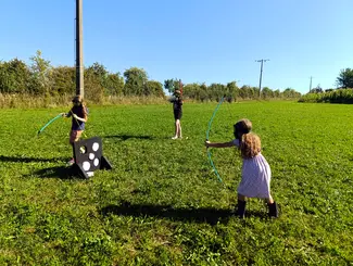 Photo de 3 enfants jouant à l'archery tag avec l'équipement du Famenne & Art Museum