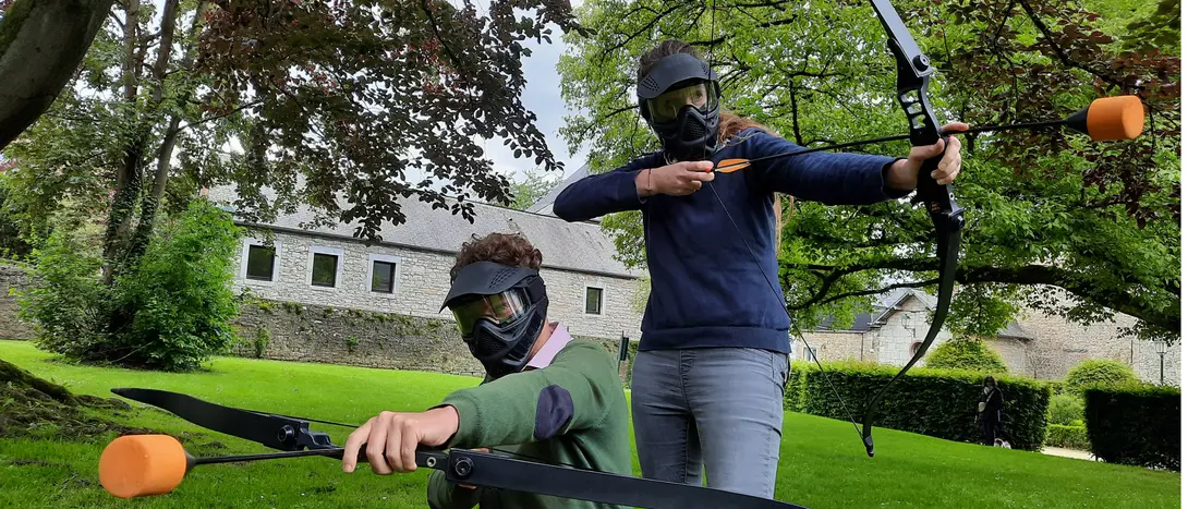 Photo de deux archers adultes posant côte à côte avec leur arc prêts à tirer